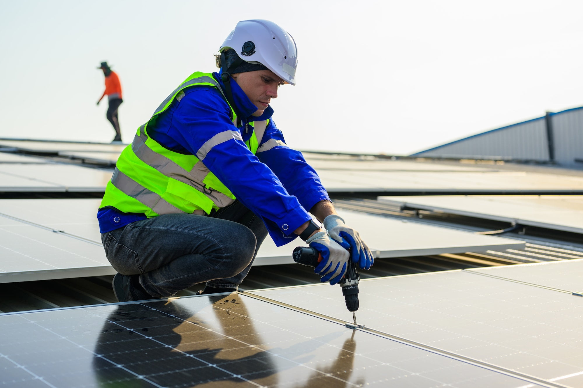 professional-technicians-installing-solar-panels-on-rooftop-of-plant
